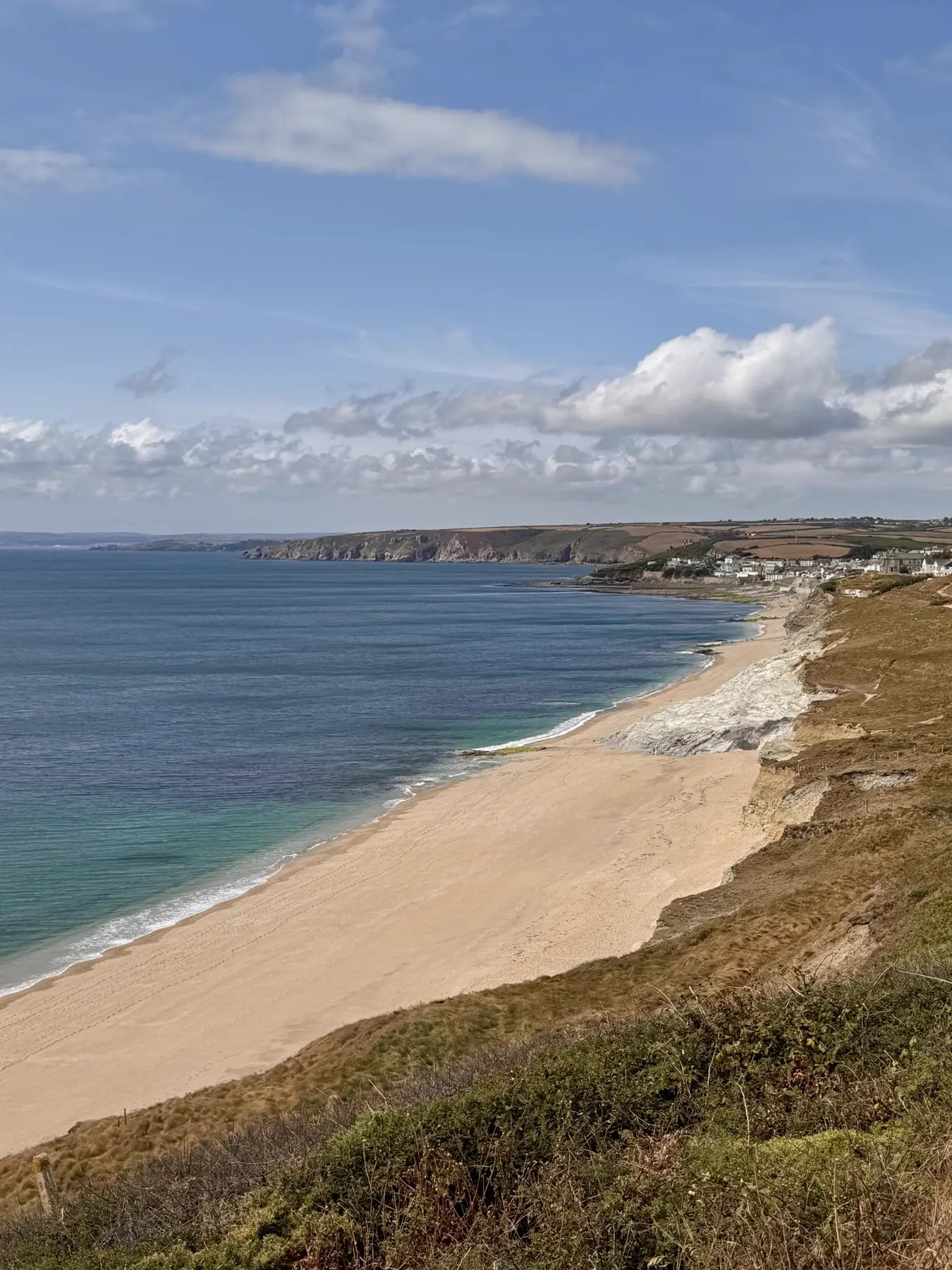 View from the cliffs on the coast path looking back along the beach towards Porthleven