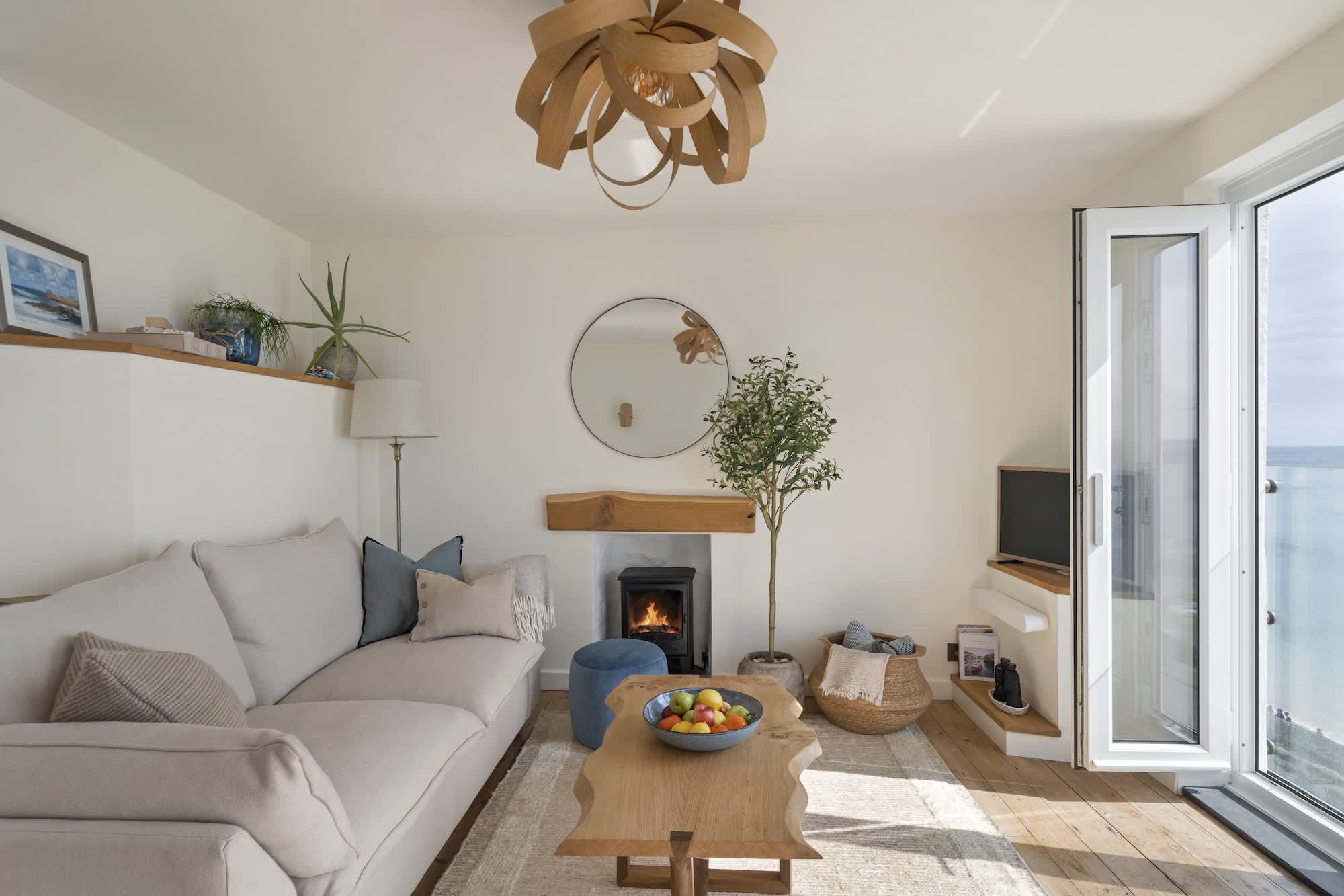 Open-plan living space with wood burner and exposed beams at Triton